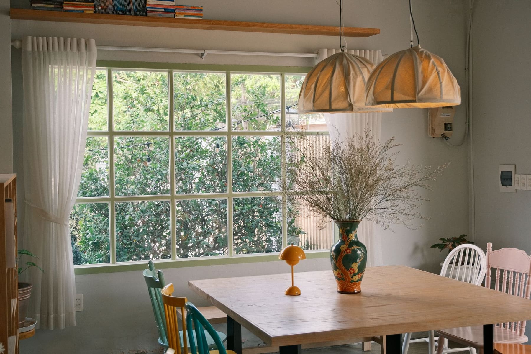 A bright dining room with a wooden table and a large window